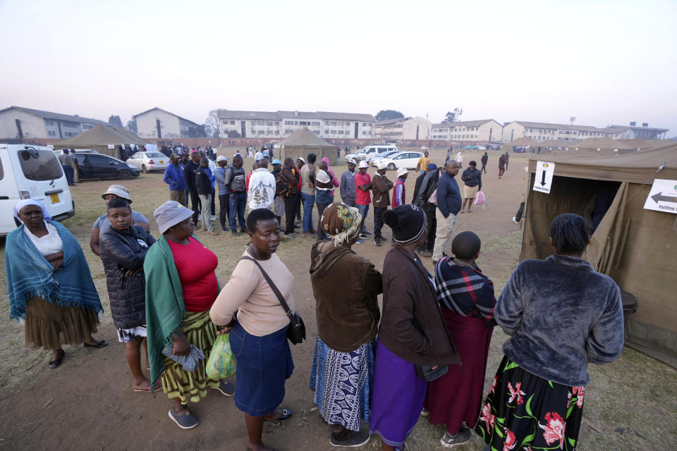 Voters wait in a queue to cast their votes at a polling station in Harare, Zimbabwe, Wednesday, Aug. 23, 2023. Polls have opened in Zimbabwe as President President Emmerson Mnangagwa seeks a second and final term in a country with a history of violent and disputed votes. (AP Photo/Tsvangirayi Mukwazhi)