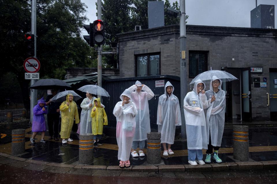 2023年7月30日，北京，旅遊區内的人們穿著雨衣。攝：Thomas Peter/Reuters/達志影像