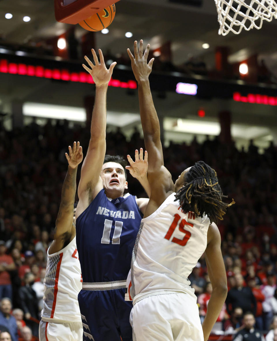 Nevada forward Nick Davidson (11) scores over New Mexico forward JT Toppin (15) during the first half of an NCAA college basketball game, Sunday, Jan. 28, 2024, in Albuquerque, N.M. (AP Photo/Eric Draper)