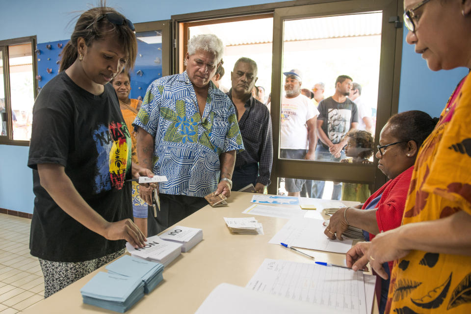 People line up at a polling station in Noumea, New Caledonia, as they prepare to cast their votes as part of an independence referendum, Sunday, Nov. 4, 2018. Voters in New Caledonia are deciding whether the French territory in the South Pacific should break free from the European country that claimed it in the mid-19th century. (AP Photo/Mathurin Derel)