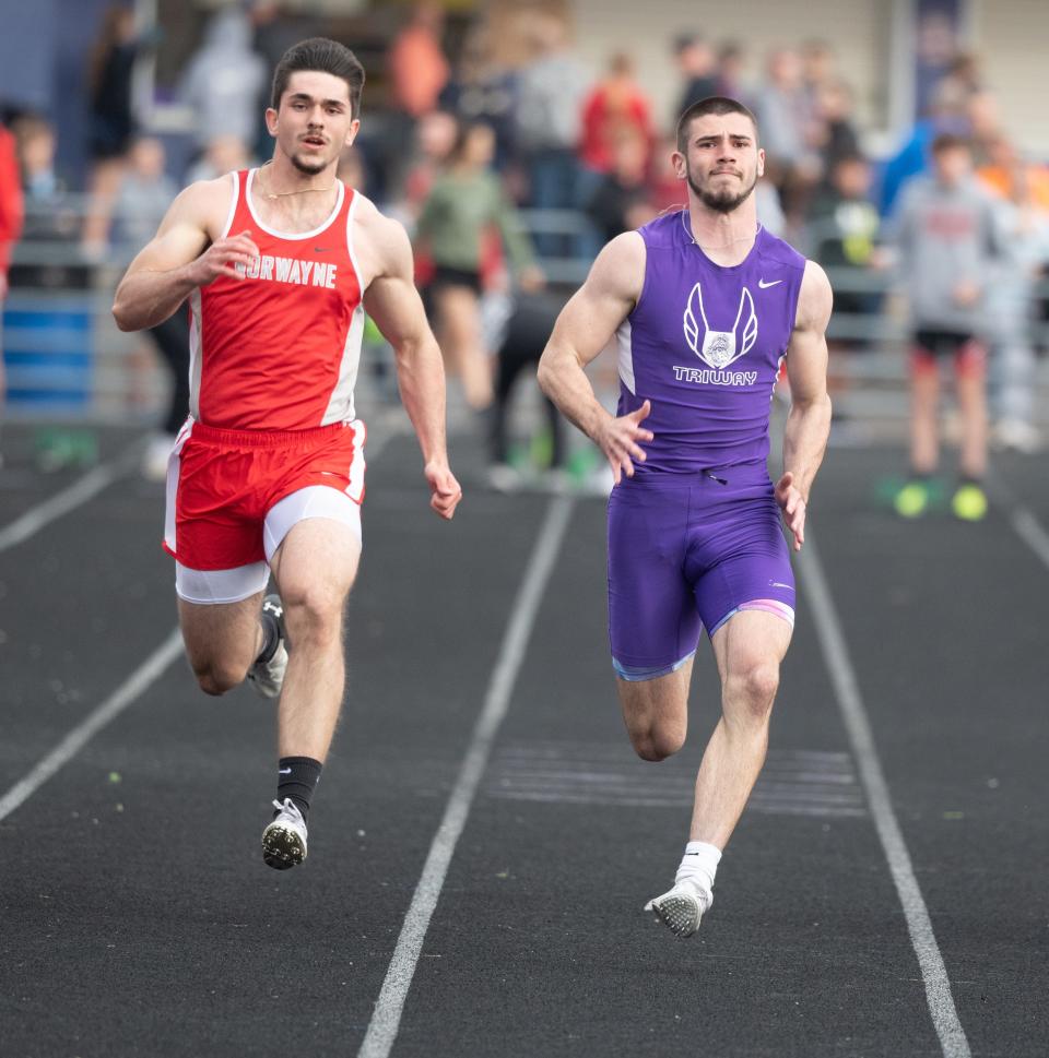 Triway's Cameron Soss (right) wins the 100 meters, as Norwayne's Brady Lendon gives chase.