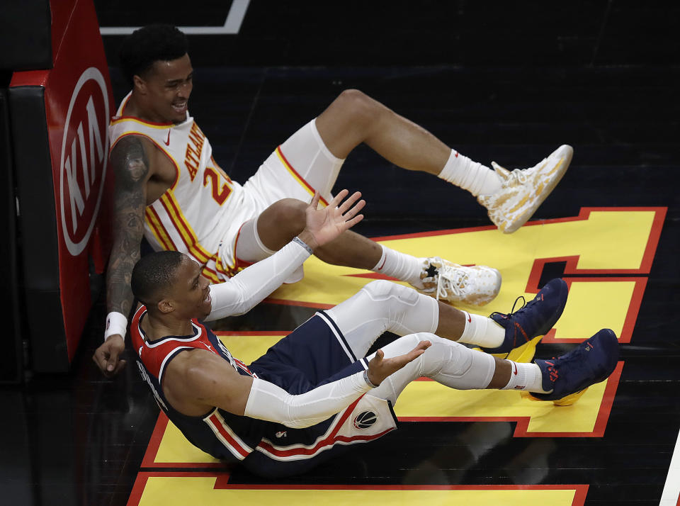 Washington Wizards' Russell Westbrook, foreground, reacts beside Atlanta Hawks' John Collins on the floor in the second half of an NBA basketball game Monday, May 10, 2021, in Atlanta. (AP Photo/Ben Margot)