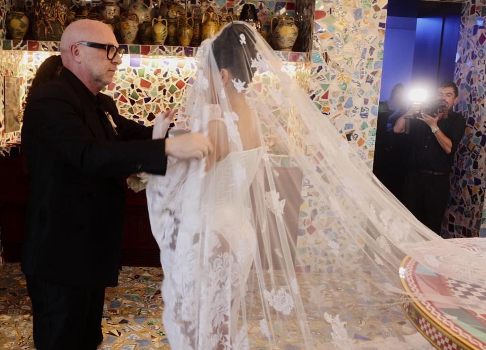 Domenico Dolce fixes Kourtney Kardashian Barker's veil ahead of her wedding to drummer Travis Barker in Portofino, Italy.