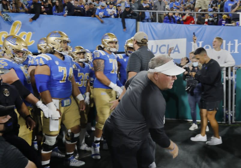 PASADENA, CA - SEPTEMBER 18, 2021: UCLA coach Chip Kelly dashes on to the field ahead.