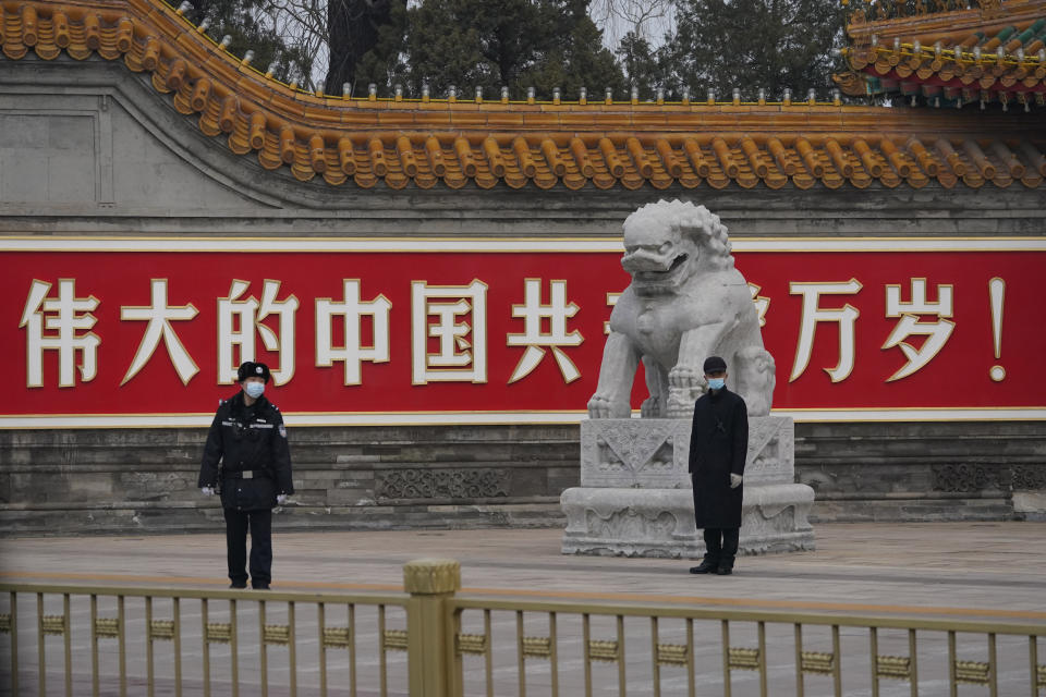 Chinese security personnel guard an entrance to the Zhongnanhai leadership compound near the words 