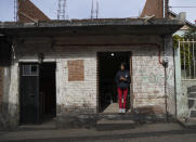 Andrea Sanchez, who migrated without documents to California with her family as a young child in 2002 and studied at U.S. schools through the sixth grade, stands in the doorway of her home in the Purepecha Indigenous community of Comachuen, Michoacan state, Mexico, Wednesday, Jan. 19, 2022. When her family returned to Comachuen, she said, “it was a big shock ... it was really different.” In the decade since, she has learned to love her hometown, even if it doesn’t have the large homes and well-kept yards she saw in her childhood. “This is home. This culture calls to me.” (AP Photo/Fernando Llano)