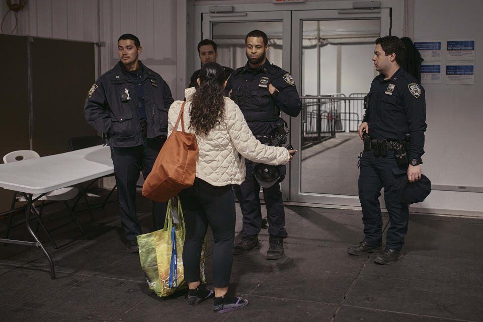 Una migrante habla con la policía en un albergue para migrantes en Randall's Island, el martes 9 de abril de 2024, en Nueva York. (AP Foto/Andres Kudacki, Archivo)