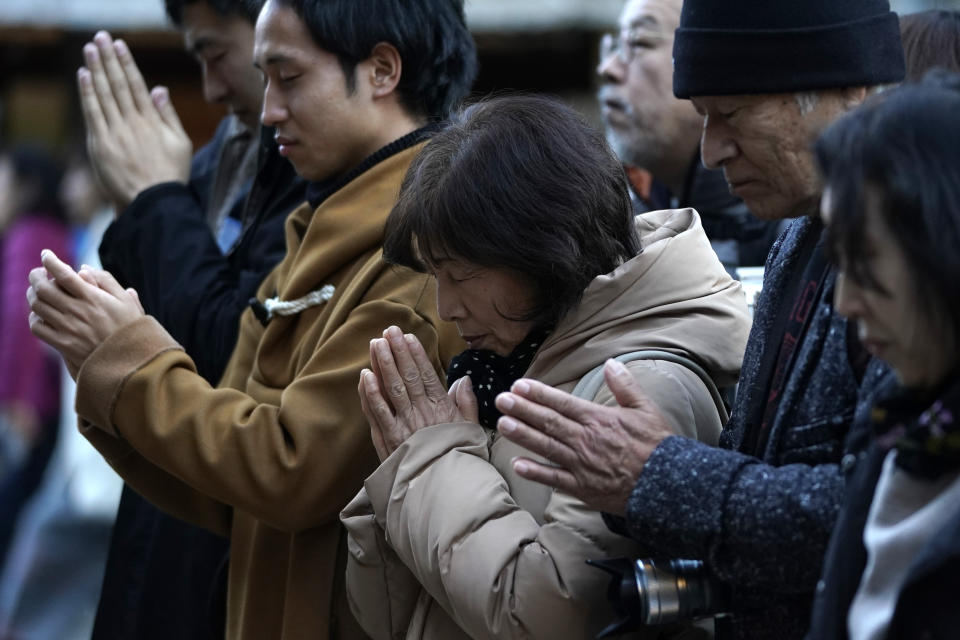 In this Tuesday, Dec. 3, 2019, photo, people pray at the Chichibu Shrine during the Chichibu Night Festival in Chichibu, north of Tokyo, Japan. This two-day festival has its roots in an older tradition of villagers giving thanks to the nearby mountain god for helping them during the planting and harvesting season, according to the chief priest of the shrine. (AP Photo/Toru Hanai)