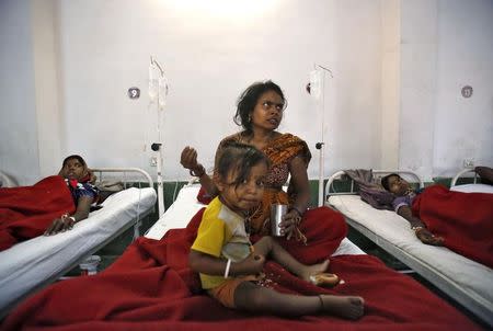 Women, who underwent a sterilization surgery at a government mass sterilisation "camp", lie in hospital beds for treatment as a child looks on at Chhattisgarh Institute of Medical Sciences (CIMS) hospital in Bilaspur, in the eastern Indian state of Chhattisgarh, November 13, 2014. REUTERS/Anindito Mukherjee