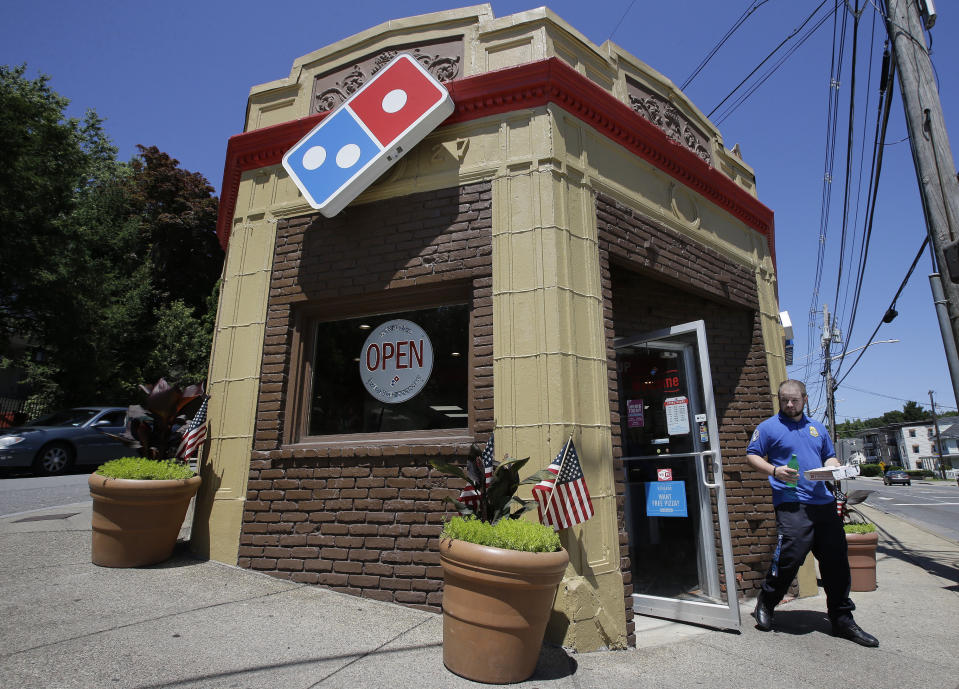 In this Monday, July 15, 2019 photo a customer departs a Domino's location holding food items, in Norwood, Mass. Domino's Pizza Inc. reports earns Tuesday, July 16. (AP Photo/Steven Senne)