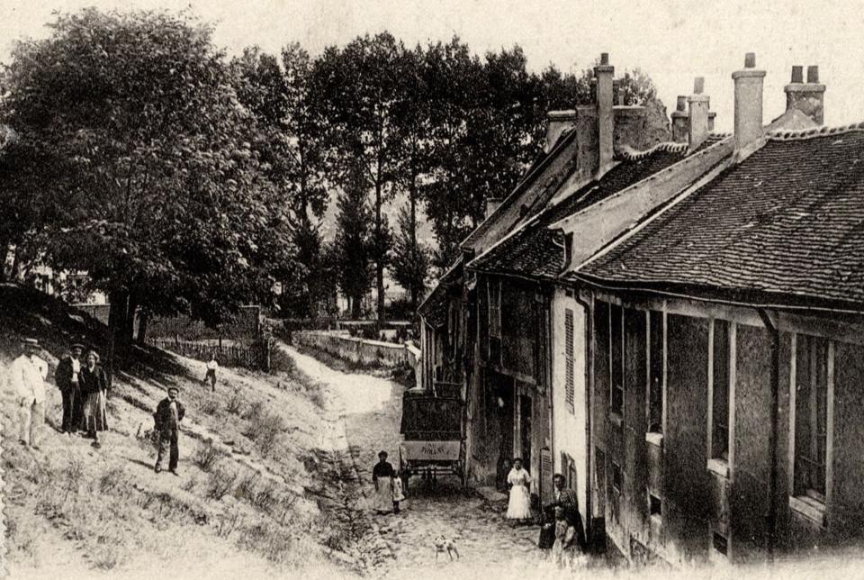 A vintage postcard printed around 1910 shows Gaudry street, with a dozen people walking down the road or milling on the grass. (Reuters)