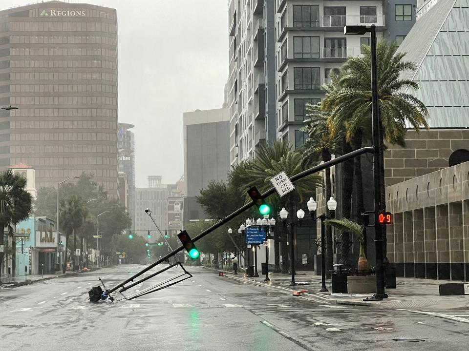 A stoplight pole at Livingston Street, blown down by Hurricane Ian winds, rests on Orange Avenue in Downtown Orlando, Fla. Hurricane Ian has left a path of destruction in southwest Florida, trapping people in flooded homes, damaging the roof of a hospital intensive care unit and knocking out power. (Willie J. Allen Jr./Orlando Sentinel via AP)