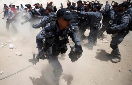 An Israeli policeman reacts during a scuffle with Palestinians in the Bedouin village of al-Khan al-Ahmar near Jericho in the occupied West Bank July 4, 2018. REUTERS/Mohamad Torokman