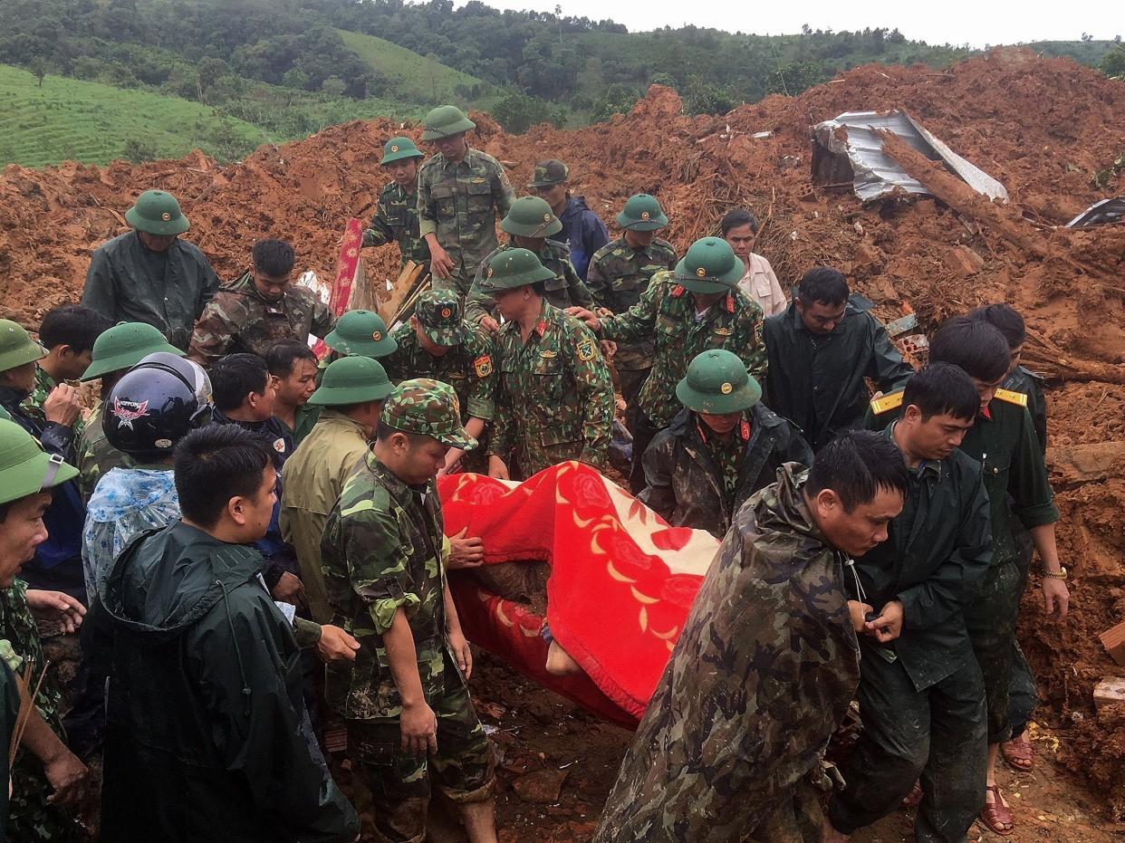 Military personnel carrying a body recovered from the site of a landslide in central Vietnam’s Quang Tri province (Vietnam News Agency/AFP via Gett)