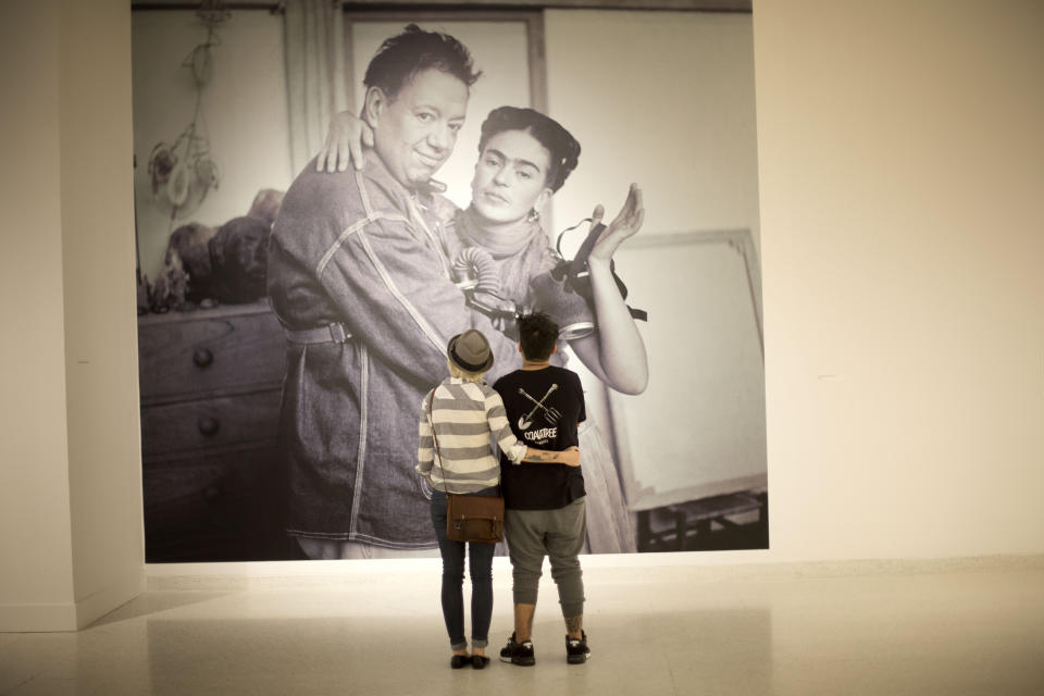 ARCHIVO - Autumn Williams y Mateo Londoño ven una fotografía de 1938 de Nickolas Muray titulada "Frida y Diego con máscara de gas" en la exposición de arte de Frida Kahlo y Diego Rivera organizada por el Museo de Arte NSU en Fort Lauderdale, Florida, el 10 de marzo de 2015. El 70 aniversario de la muerte de Kahlo es el 13 de julio de 2024. (AP Foto/J Pat Carter, Archivo)