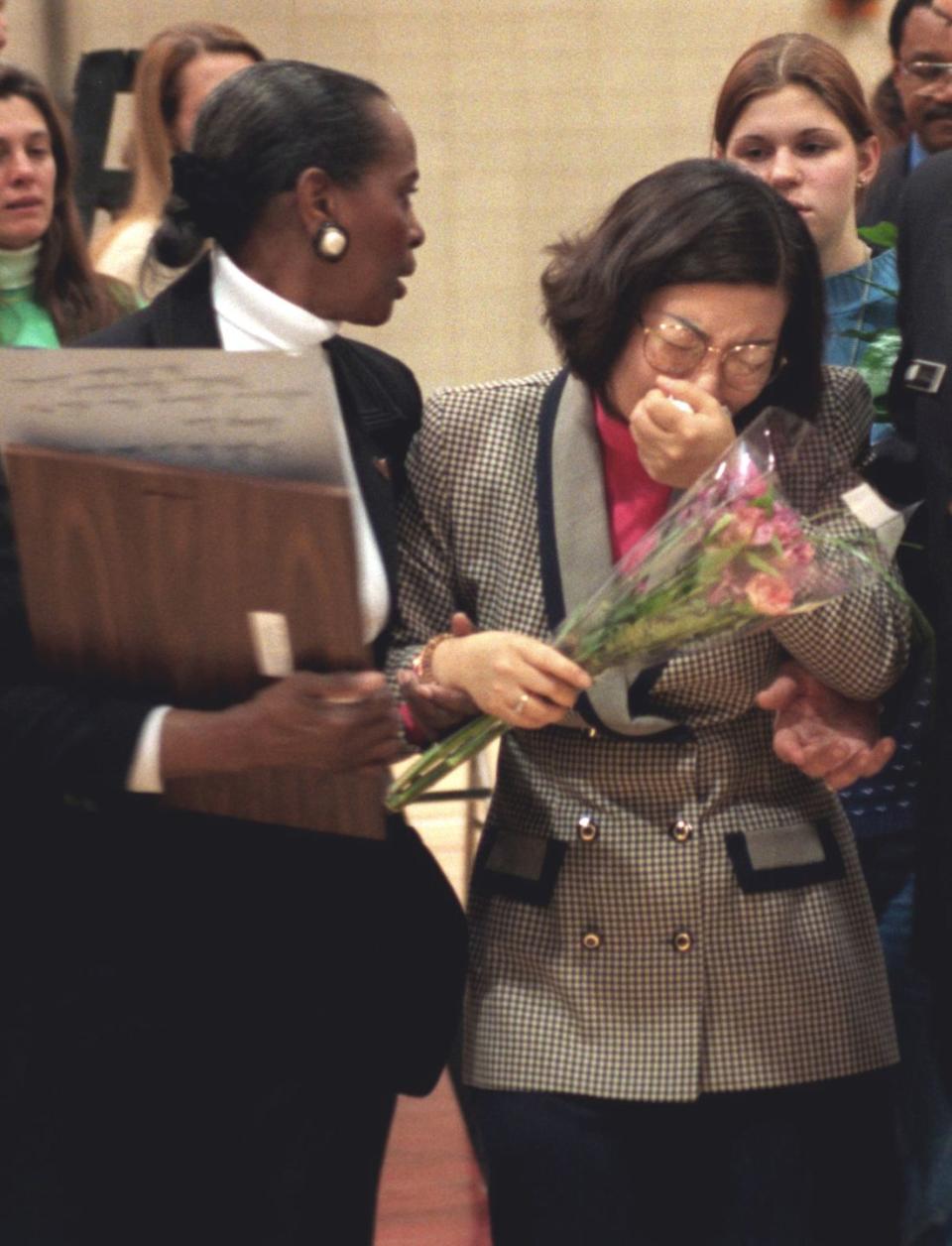 youn kim, mother of hae min lee, is escorted from her daughter's memorial service by guidance counselor gwen kellam, on march 11, 1999, in baltimore, maryland