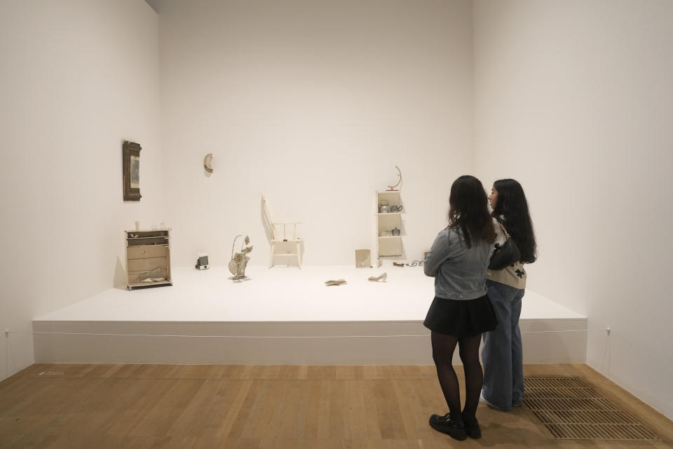 Two members of staff stand in front of a work entitled Half a Room 1967 at the Yoko Ono : Music of the Mind exhibition at the Tate Modern, the works of art are copyright Yoko Ono, In London, Tuesday, Feb. 13, 2024. The exhibition which has many pieces that are interactive and the public and participate in, runs from Feb.15, to Sept. 1. (AP Photo/Alastair Grant)