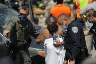 Authorities guide a person after an explosion in Baltimore on Monday, Aug. 10, 2020. Baltimore firefighters say an explosion has leveled several homes in the city. (AP Photo/Julio Cortez)