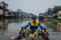 Local resident Le Ngoc Chau makes money collecting scrap from the polluted waterways