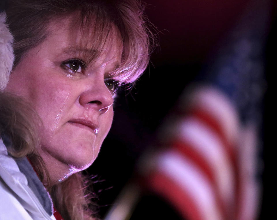 People line the street for a procession from a Rockford, Ill. hospital to the funeral home Friday, March 8, 2019, in Huntley, Ill., for fallen McHenry County Sheriff's Deputy Jacob Keltner. Elizabeth Hartzog of Huntley weeps as the hearse passes. An Illinois man faces federal murder charges in the shooting death of the sheriff's deputy that led to an hourslong standoff with police along an interstate. (Patrick Kunzer/Daily Herald via AP)