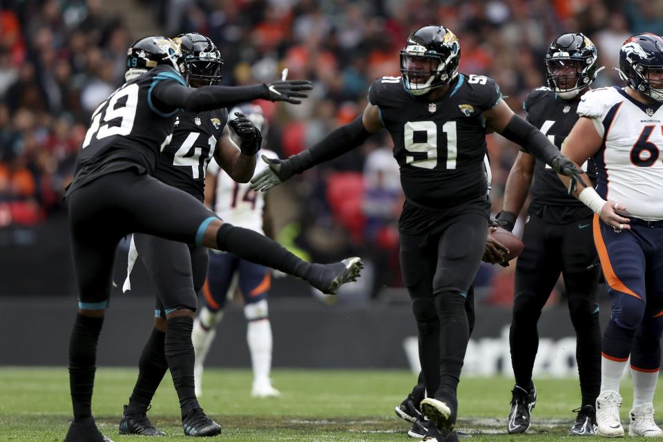 Jacksonville Jaguars defensive end Dawuane Smoot (91), and Jacksonville Jaguars defensive end Arden Key (49) celebrate during the NFL football game between Denver Broncos and Jacksonville Jaguars at Wembley Stadium in London, Sunday, Oct. 30, 2022. (AP Photo/Ian Walton)