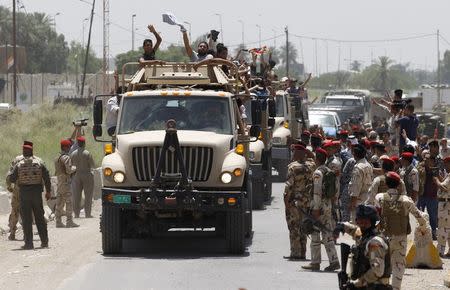 Volunteers, who have joined the Iraqi Army to fight against the predominantly Sunni militants who have taken over Mosul and other Northern provinces, travel in army trucks in Baghdad June 14, 2014. REUTERS/Thaier Al-Sudani