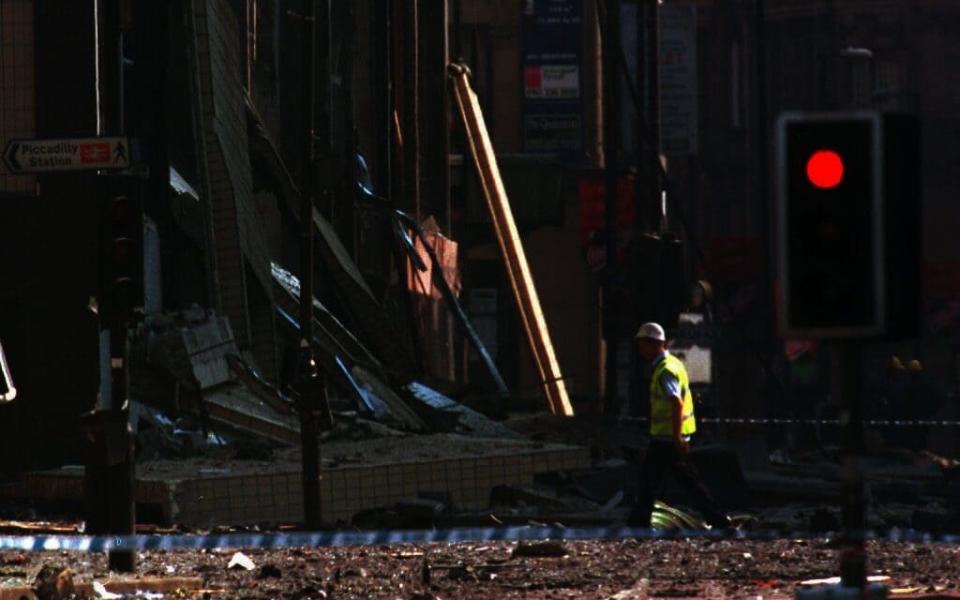 A forensic expert walks towards the destroyed facade of the Arndale shopping centre on June 15, 1996 - Credit: Oliver Multhaup/EPA