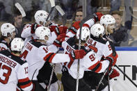 New Jersey Devils defenseman Dougie Hamilton (7) is congratulated by teammates after scoring the game winning goal against the New York Rangers in overtime of Game 3 of the team's NHL hockey Stanley Cup first-round playoff series Saturday, April 22, 2023, in New York. The Devils won 2-1. (AP Photo/Adam Hunger)