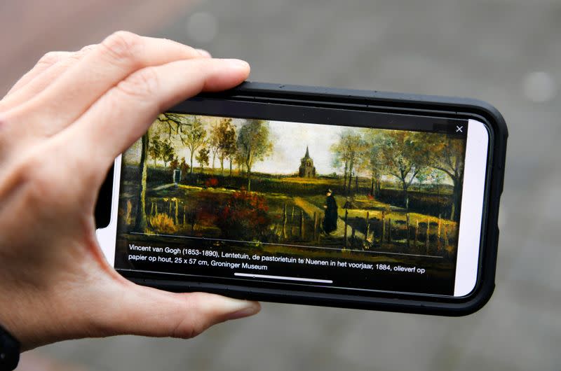 A person holds a cellphone displaying "Spring Garden", the work of art by Vincent van Gogh that was stolen, outside the Singer Laren Museum, in Laren