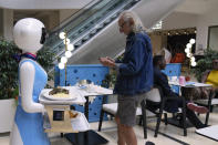 Robotic waiter Claire, delivers an order to customers at the Robot Cafe in Nairobi, Kenya Thursday, Aug. 29, 2024. The three robots, christened Claire, R24 and Nadia, are not programmed to have a full conversation with customers, but they can say "Your order is ready, Welcome" then people have to press an exit button after picking up their food from the tray. (AP Photo/Brian Inganga)