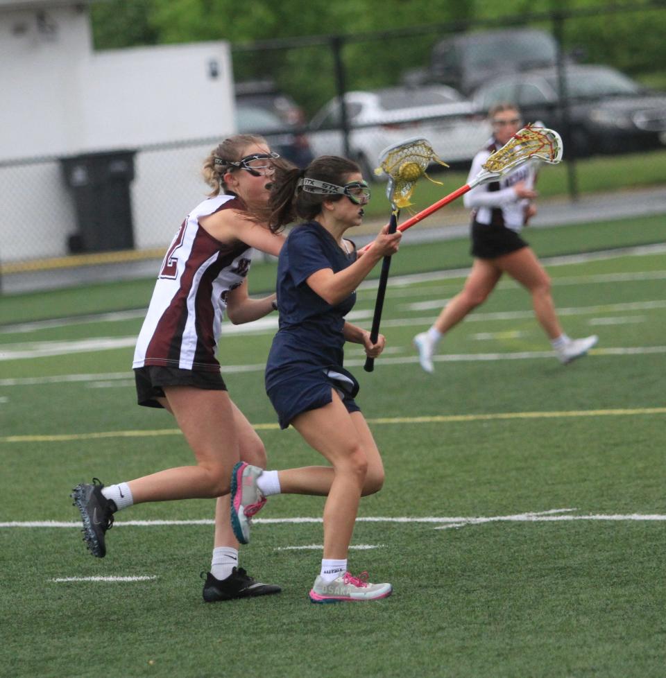 Granville's Gwyn Smith attempts to drive past Newark's Peyton Sherman during the visiting Blue Aces' 17-2 victory at White Field on Thursday, May 9, 2024.