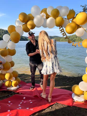 <p>Rachel Stanley Photography</p> Gary Wayne proposes to Ali Taylor under a balloon arch.