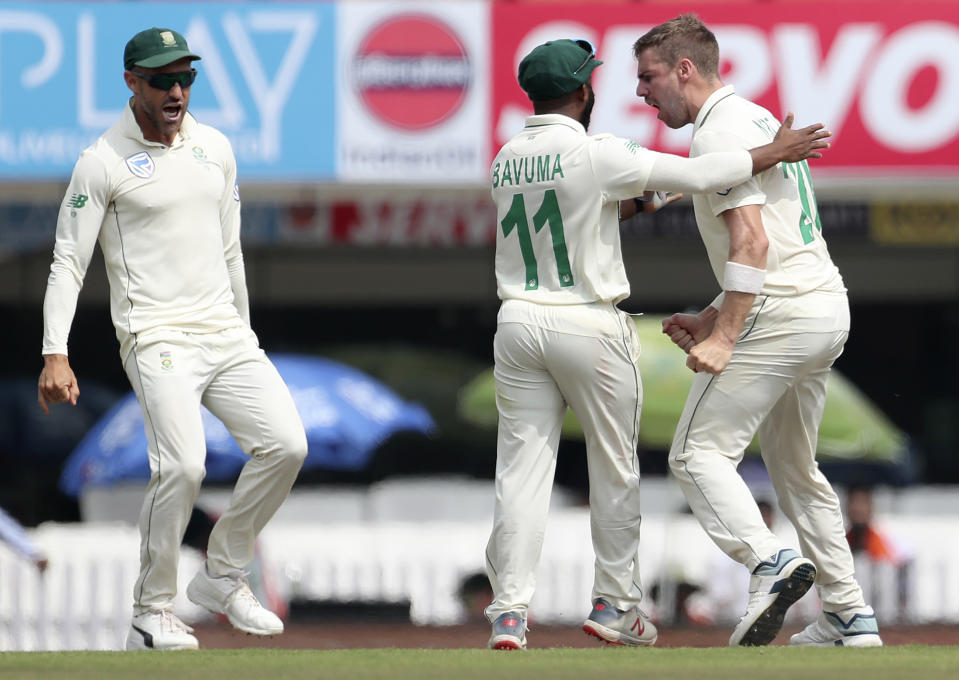 South Africa's captain Faf du Plessis, left, runs to celebrate with Anrich Nortje, right, the dismissal of India's captain Virat Kohli during the third and last cricket test match between India and South Africa in Ranchi, India, Saturday, Oct. 19, 2019. (AP Photo/Aijaz Rahi)