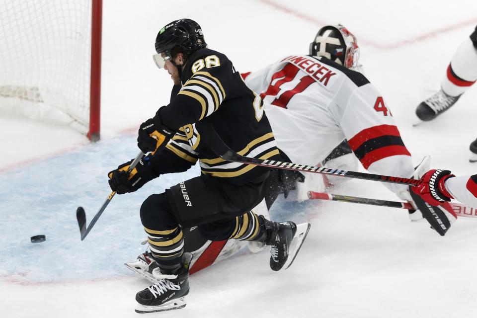 Boston Bruins' David Pastrnak (88) scores against New Jersey Devils' Vitek Vanecek (41) for the second time during the second period of an NHL hockey game Saturday, Dec. 30, 2023, in Boston. (AP Photo/Michael Dwyer)