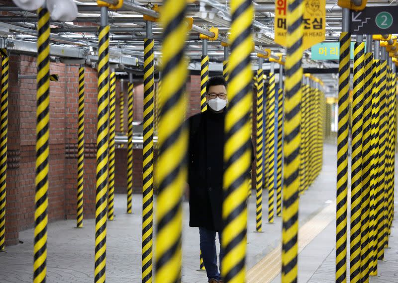 Un hombre que lleva una máscara como medida preventiva contra el coronavirus camina en una estación de metro en Seúl, Corea del Sur