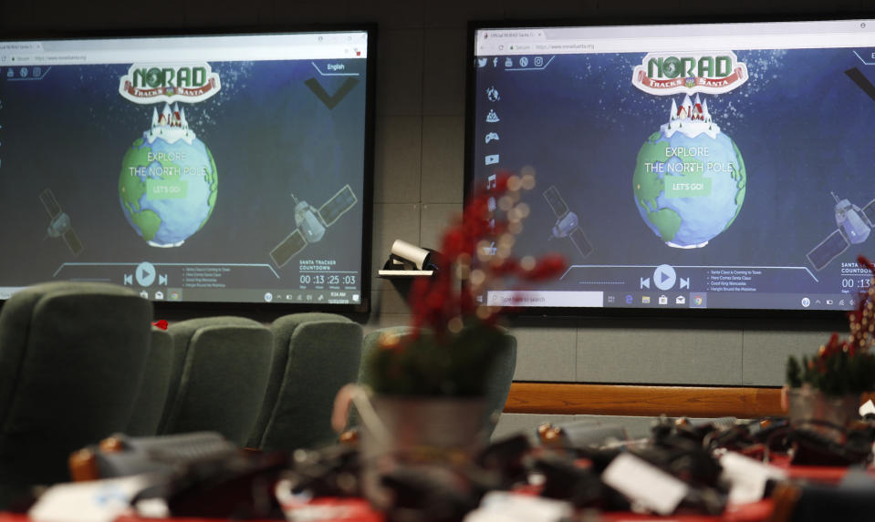 FILE - In this Dec. 23, 2019, file photo monitors are illuminated in the NORAD Tracks Santa center at Peterson Air Force Base in Colorado Springs, Colo. The North American Aerospace Defense Command has announced that NORAD will track Santa on December 24, just as it has done for 65 years. But there will be some changes: Not every child will be able to get through to a volunteer at NORAD’s call center to check on Santa’s whereabouts, as they have in years before. (AP Photo/David Zalubowski, File)