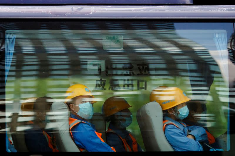 Workers leave a construction site at the end of their shift in the Central Business District in Beijing