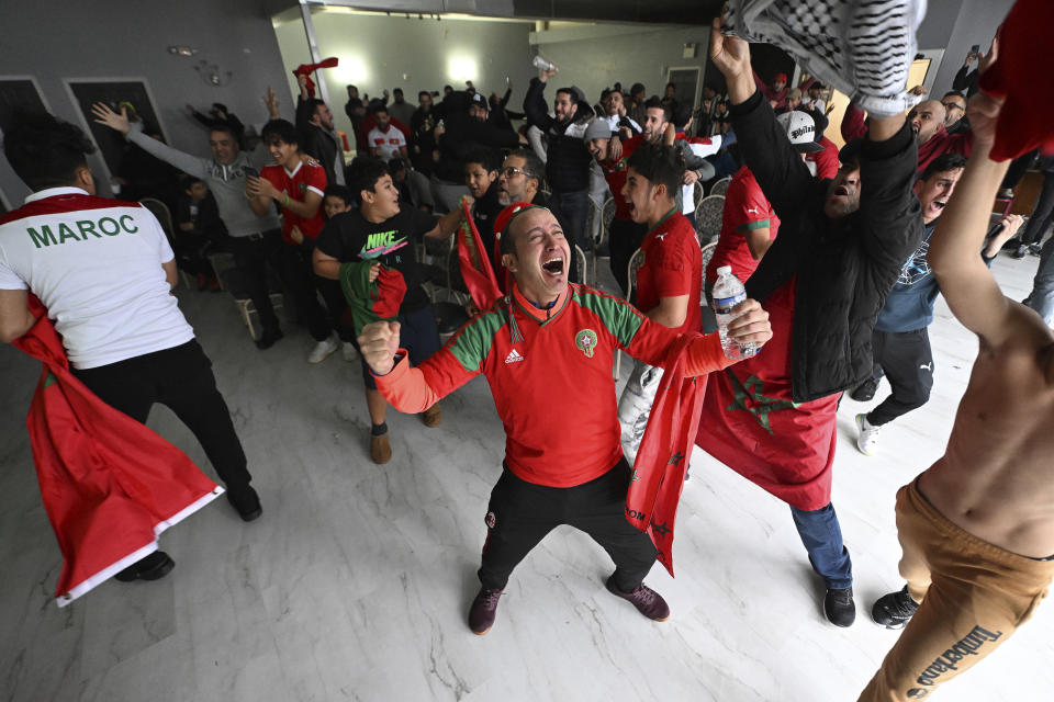 Mimoune Hassa, center, celebrates their team's victory as they watch the World Cup soccer match on TV at Akbar restaurant Tuesday, Dec. 6, 2022 in Philadelphia. Morocco defeated Spain on penalty kicks. (Jose F. Moreno/The Philadelphia Inquirer via AP)