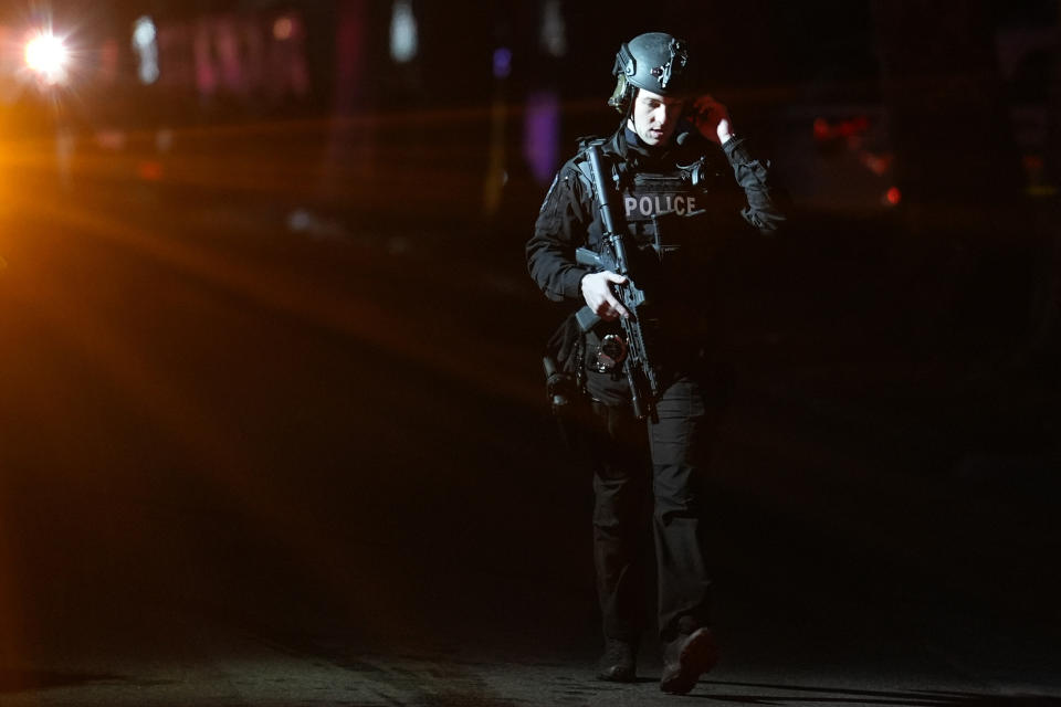 A police officer walks away from the scene where two officers were injured while responding to reported standoff in East Lansdowne, Pa., on Wednesday, Feb. 7, 2024. (AP Photo/Matt Rourke)