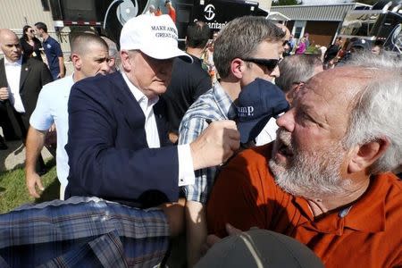 Republican presidential nominee Donald Trump signs a supporter's shirt outside Greenwell Springs Baptist Church in Central, Louisiana, U.S. August 19, 2016. REUTERS/Jonathan Bachman