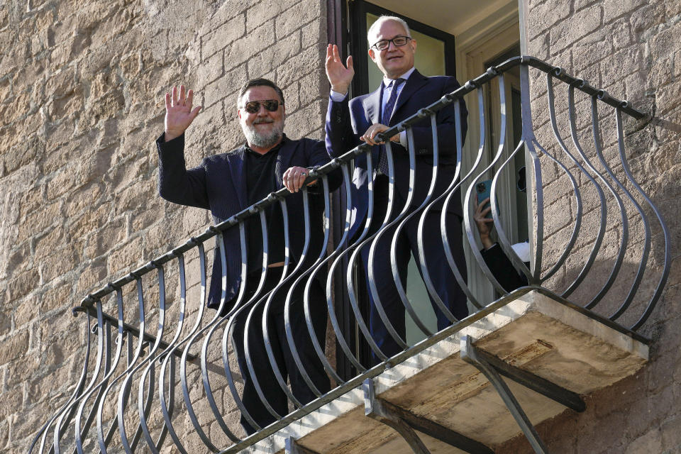 Actor Russell Crowe, left, and Rome's mayor Roberto Gualtieri wave to photographers from the balcony of the mayor's studio, prior to the "Ambassador of Rome in the World" award ceremony, in Rome's Capitol Hill, Friday, Oct. 14, 2022. (AP Photo/Andrew Medichini)