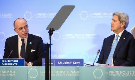 French Interior Minister Bernard Cazeneuve speaks as U.S. Secretary of State John Kerry (R) listens during the Ministerial meeting on Foreign Fighters at the White House Summit on Countering Violent Extremism at the State Department in Washington February 19, 2015. REUTERS/Joshua Roberts