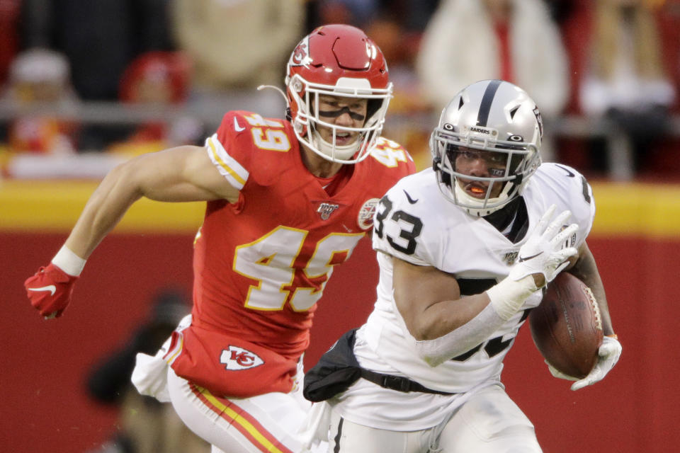 Oakland Raiders running back DeAndré Washington (33) runs away from Kansas City Chiefs safety Daniel Sorensen (49) during the first half of an NFL football game in Kansas City, Mo., Sunday, Dec. 1, 2019. (AP Photo/Charlie Riedel)