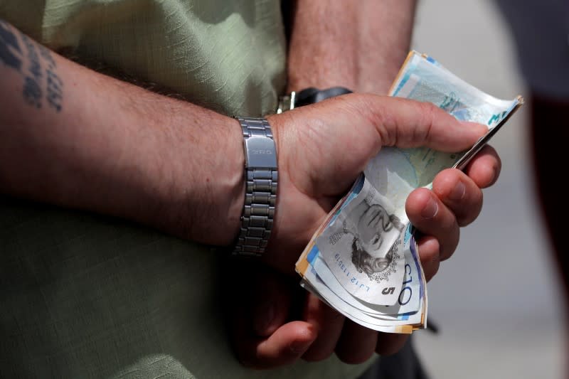 A man holds various English Pound notes as he waits in line to exchange it for Euros notes outside a money exchange office in the British overseas territory of Gibraltar, historically claimed by Spain, June 24, 2016, after Britain voted to leave the European Union in the EU BREXIT referendum. REUTERS/Jon Nazca