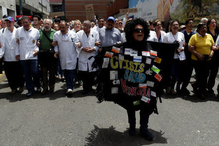 A woman wearing a costume with medicine boxes that reads "Health crisis" shouts slogans during a rally against President Nicolas Maduro's government in Caracas, Venezuela May 17, 2017. REUTERS/Marco Bello