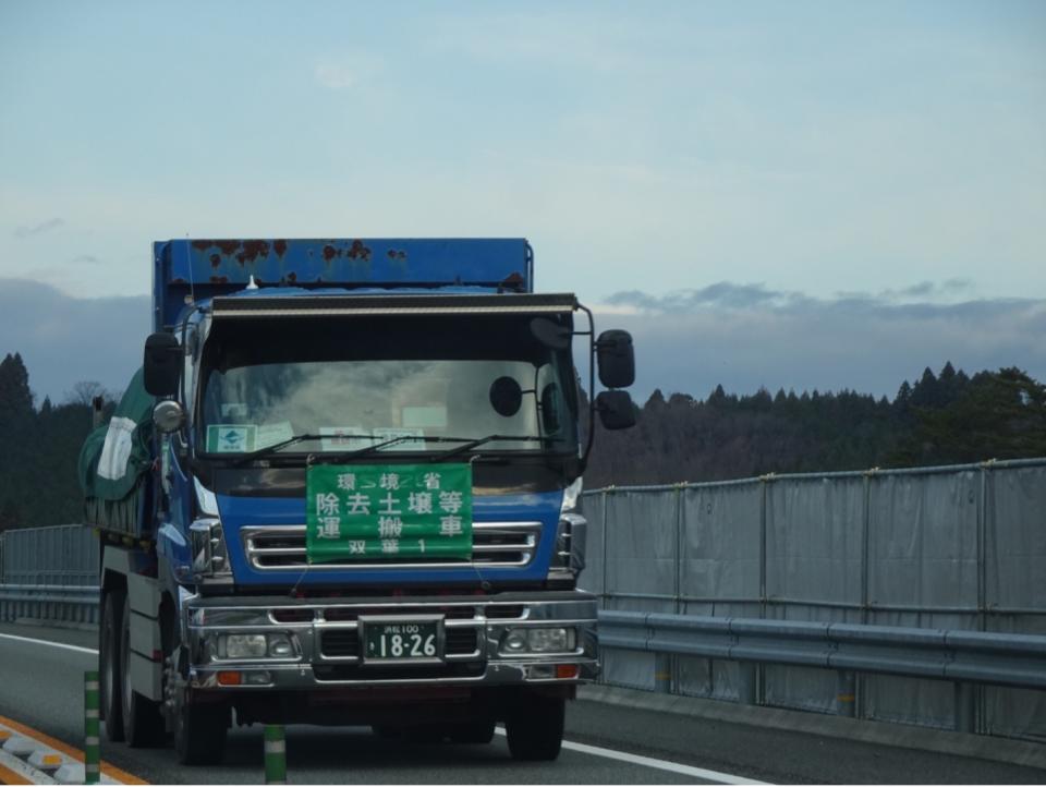 每天成千上萬輛環境省的「除去土壤等運搬車」在福島週邊把核災污染廢土搬來搬去，有了車輪的「福」，就成了「輻」，而且還要再把除污後的土壤分到福島以外的縣市享「輻」。   圖：方儉／攝