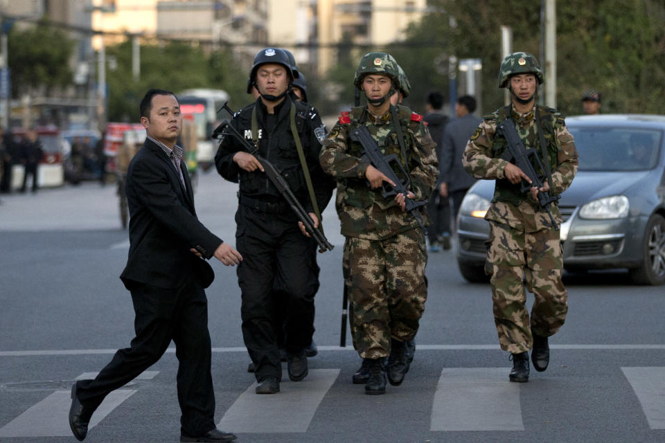 In this Monday March 3, 2014 photo, armed policemen and paramilitary policemen patrol a street near the Kunming Train Station in Kunming, in southwestern China's Yunnan province. China said the vicious slashing spree Saturday that killed 29 people in the southern city was the work of separatists linked to international terrorism, but the assailants’ homespun methods and low-tech weapons - nothing more than long knives - have led some analysts to suspect they didn’t get outside help. (AP Photo/Alexander F. Yuan)