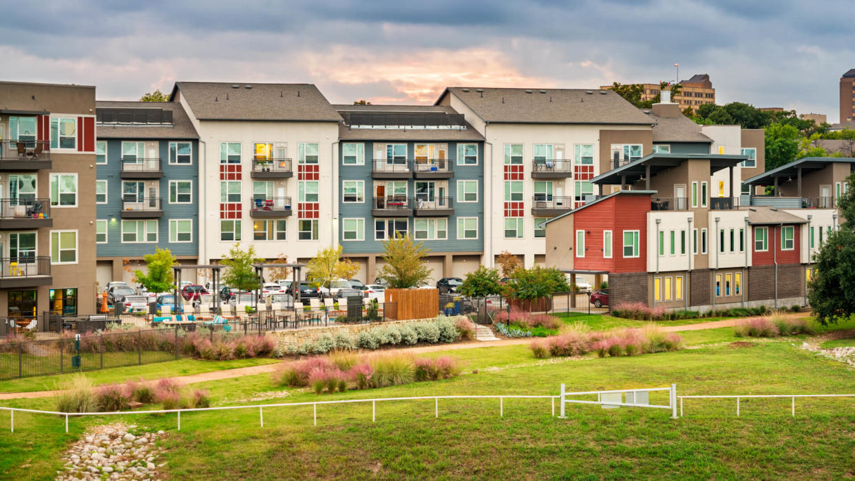 Stock photo of condominium apartment buildings with parking lot and back yard in Dallas, Texas, USA.