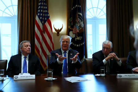 U.S. President Donald Trump, flanked by U.S. Senator Dick Durbin (D-IL) and Representative Steny Hoyer (D-MD), holds a bipartisan meeting with legislators on immigration reform at the White House in Washington, U.S. January 9, 2018. REUTERS/Jonathan Ernst