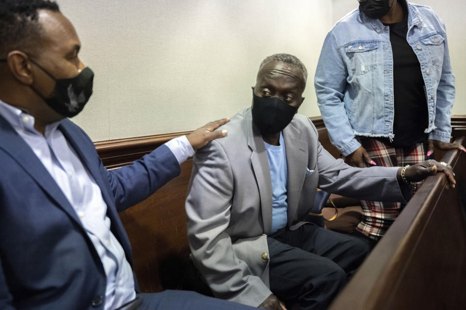 Ahmaud Arbery's father Marcus Arbery, center, and his attorney Benjamin Crump, left, leave the Glynn County Courtroom during the trial of during the trial of Greg McMichael and his son, Travis McMichael, and a neighbor, William "Roddie" Bryan, Tuesday, Nov. 9, 2021, in Brunswick, Ga. The three are charged with the February 2020 slaying of his son 25-year-old Ahmaud Arbery. (AP Photo/Stephen B. Morton, Pool)